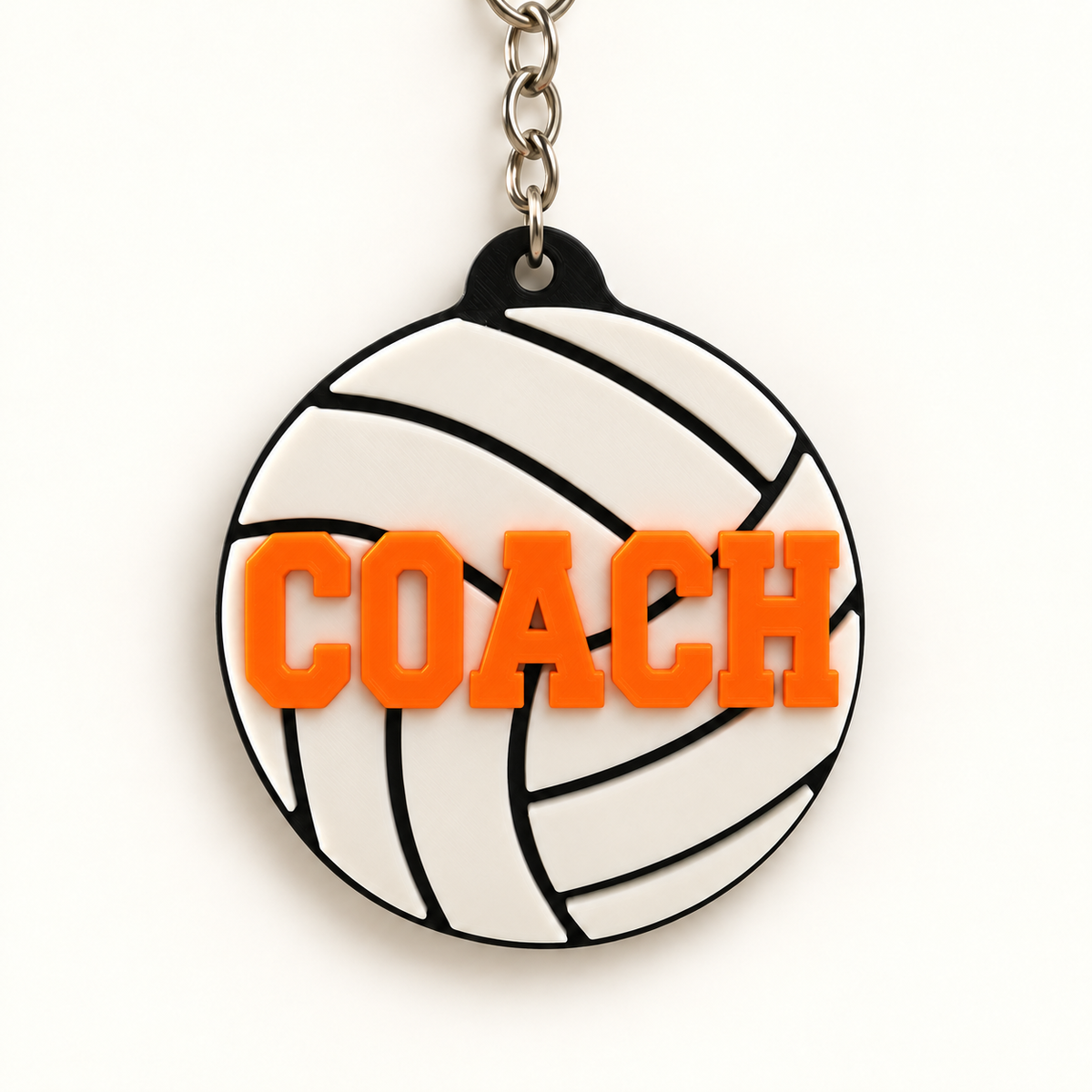 White volleyball keychain with raised orange COACH lettering
